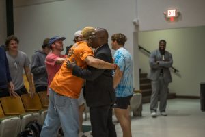 Dr. William Walker hugs a student