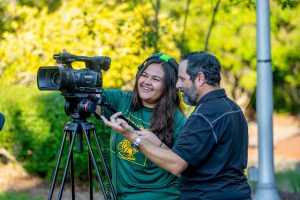 A Communication & Media student gets help from an instructor